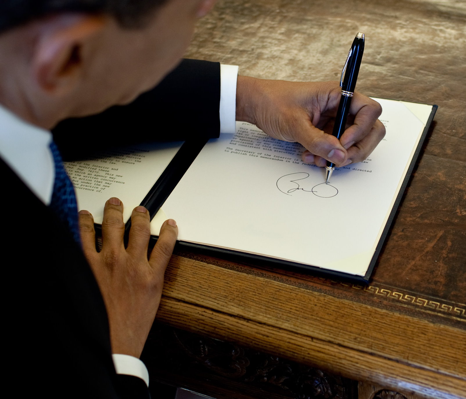 Barack Obama, presidente degli stati uniti mancino, firma un documento alla casa bianca